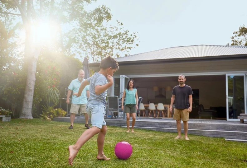 Family playing in the back yard garden at sunset