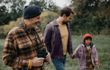 Grandfather, father and son walking in a field
